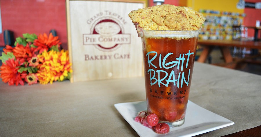beer glass from Right Brain Brewery contains ruby red beer with cherry pie dunked inside